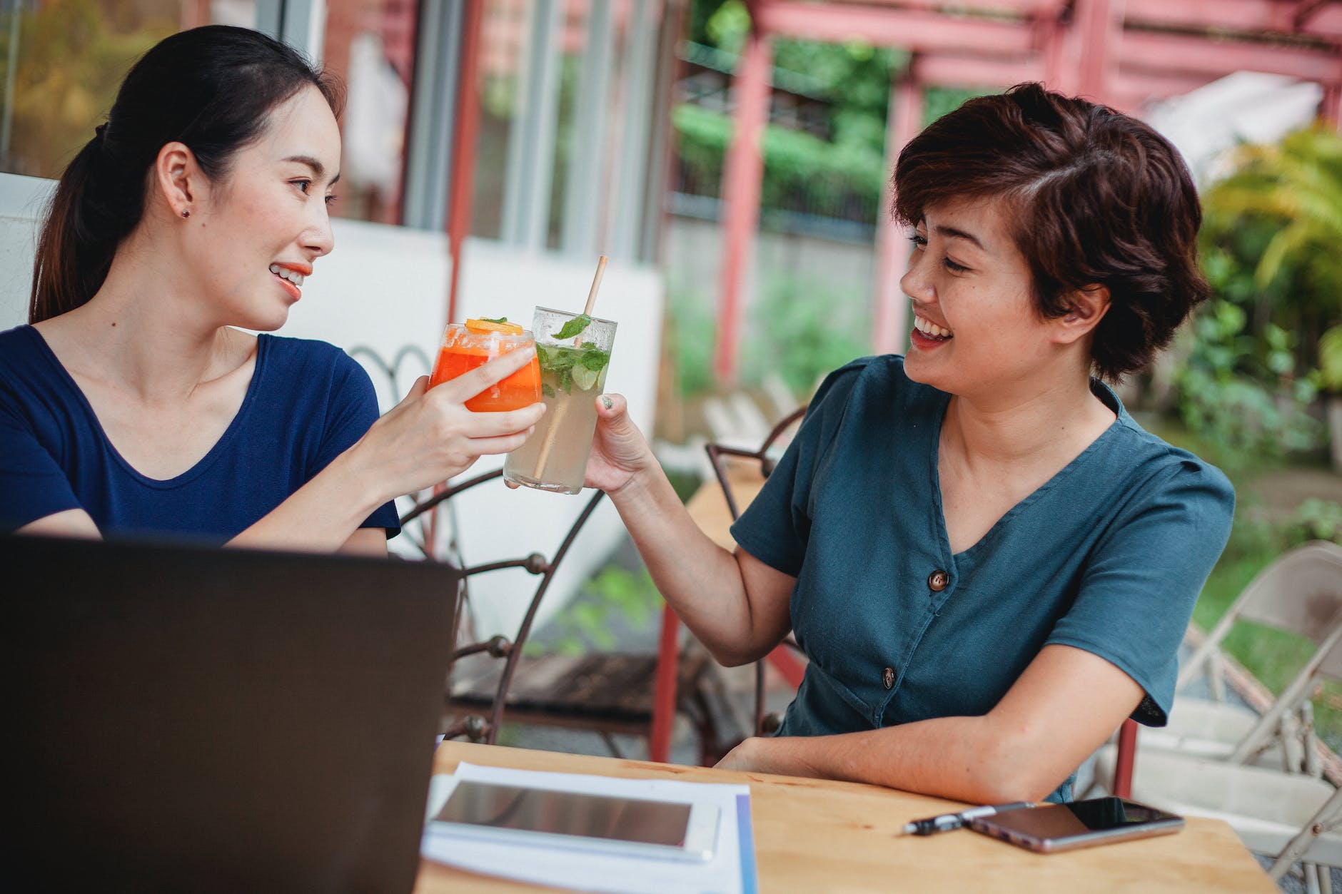 cheerful asian businesswomen with cocktails after successful deal