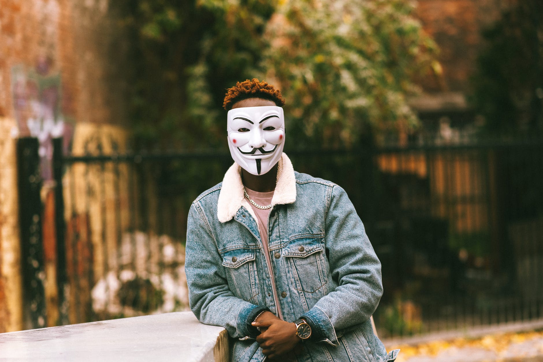 unrecognizable black man in mask of anonymous in city