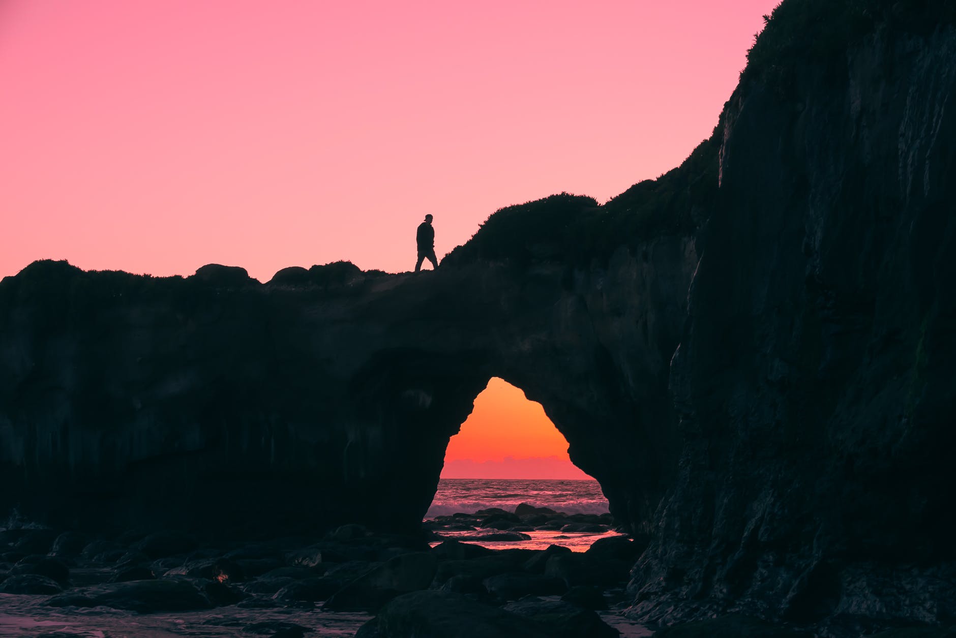 silhouette of man on rock walking during nightime